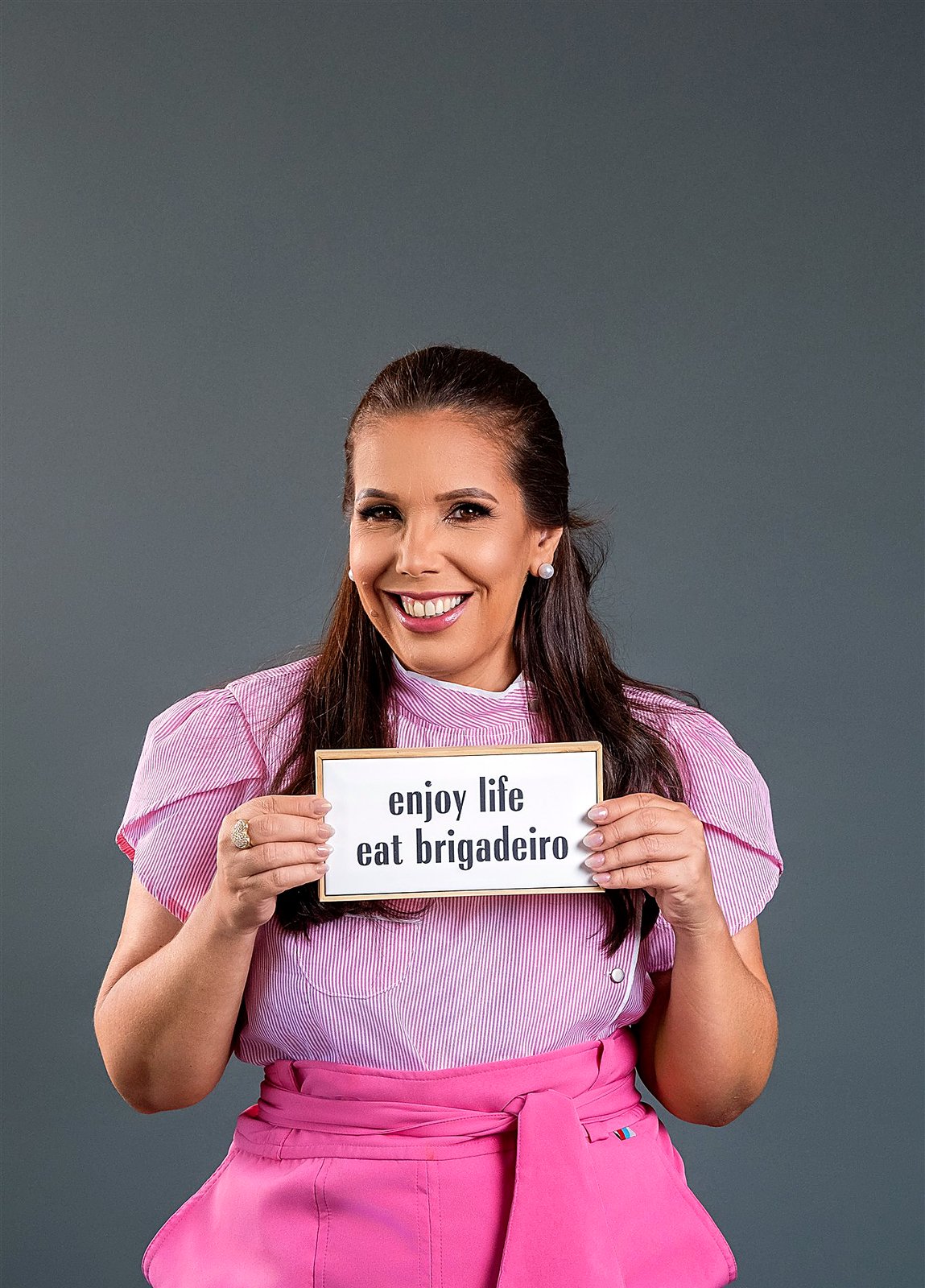 Graziella com a placa enjoy life eat brigadeiro