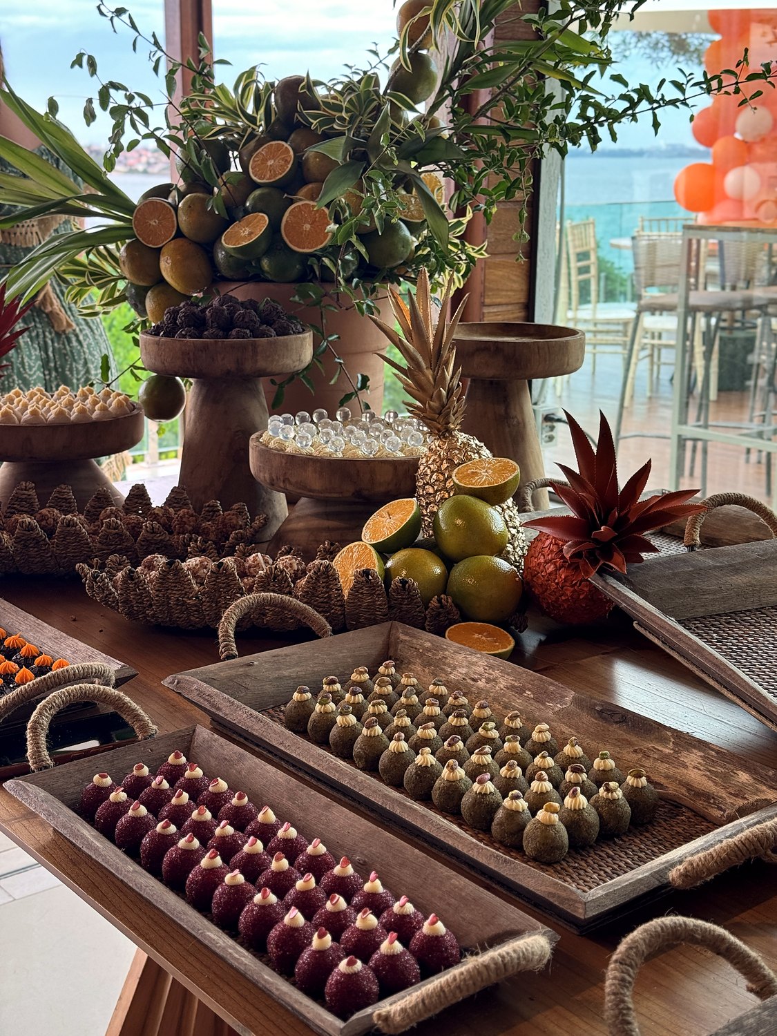 Mesa de doces tropical completa, com frutas e madeira